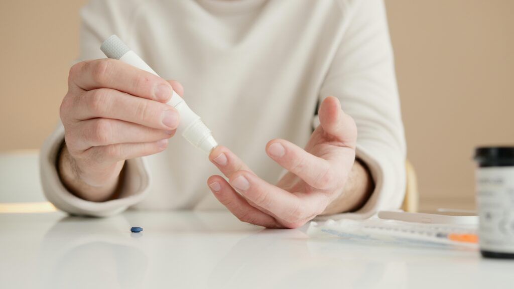 A man measures his blood sugar by taking blood from his finger with a blood sugar meter