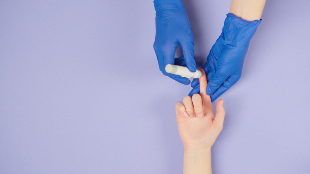 blue-gloves medical worker measures the patient's blood sugar from the patient's finger