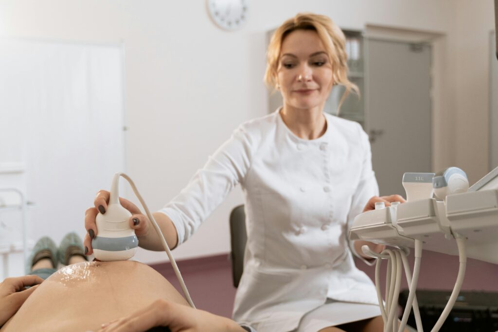 gynecologist doing ultrasound of a pregnant woman's belly