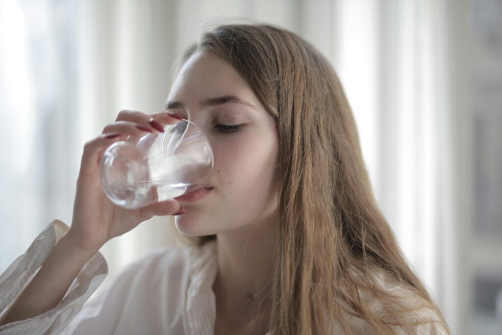 a young woman is drinking water