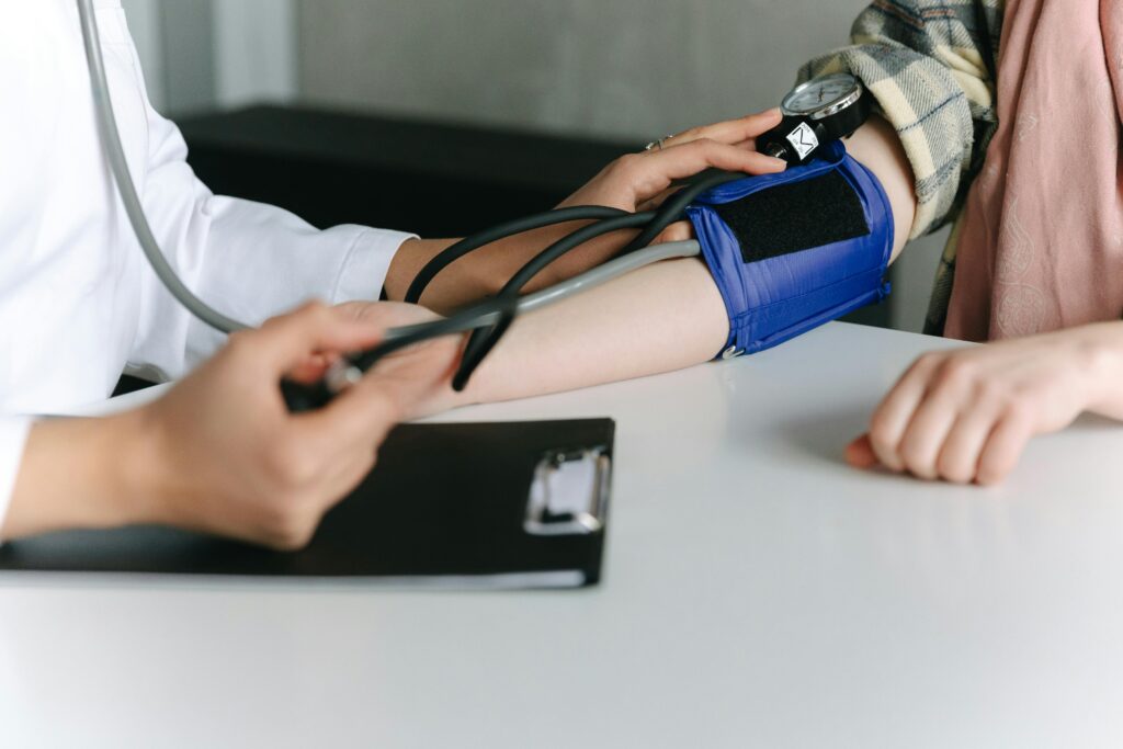 a doctor measuring patient's blood pressure with blood pressure monitor